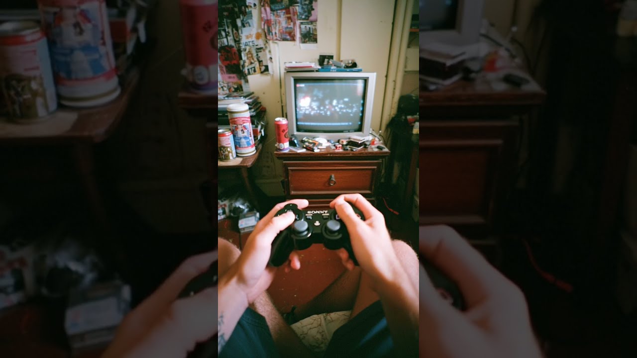 close up of a playstation 3 controller in the hands of a 17 year old boy
